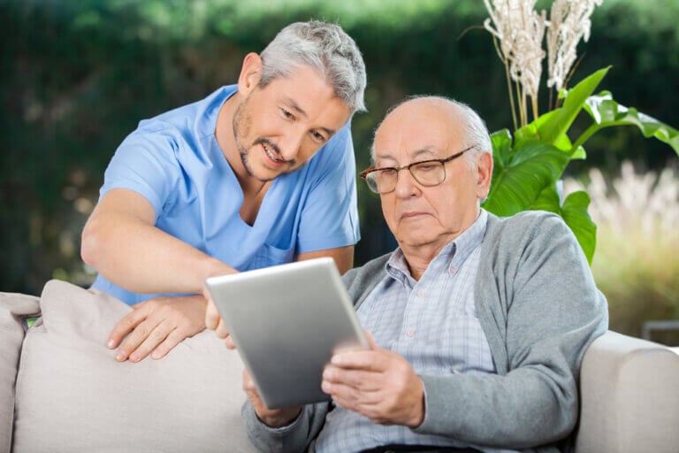 Caregiver helping elderly man understand the difference between home care and home health
