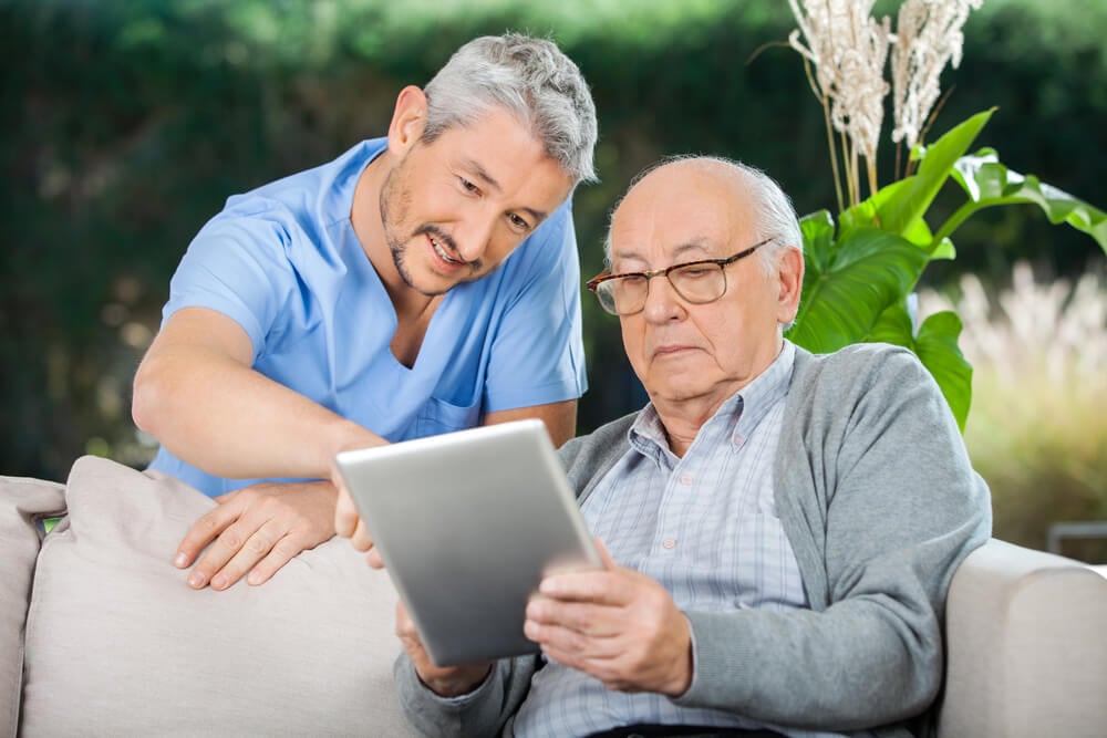 Caregiver helping elderly man understand the difference between home care and home health